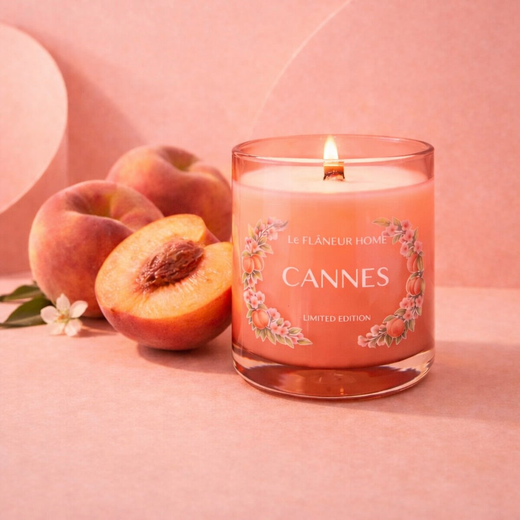 Candle labeled 'Cannes' with peaches on a pink background