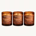Le Flâneur Home Cities of Italy candle trio: unlit Como, Firenze and Positano candles in amber glass on an ivory background.