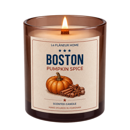 Lit Boston Pumpkin Spice scented candle by Le Flâneur Home in an amber glass jar with a wooden wick.